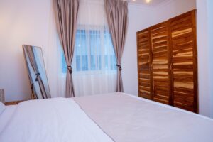 King-size bedroom with wooden wardrobe at Villa Buffalo Downstairs