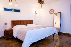 King-size bedroom and bedside lighting at Villa Komba Upstairs