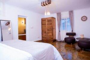 Bedroom with wooden wardrobe and seating at Villa Komba Upstairs