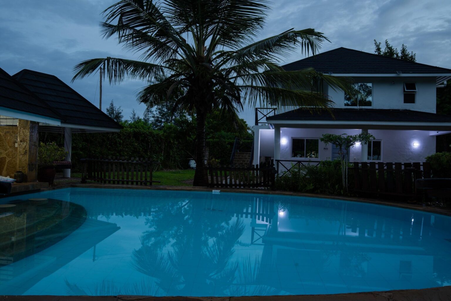 Swimming pool and main house at Coast Sun Gardens at dusk